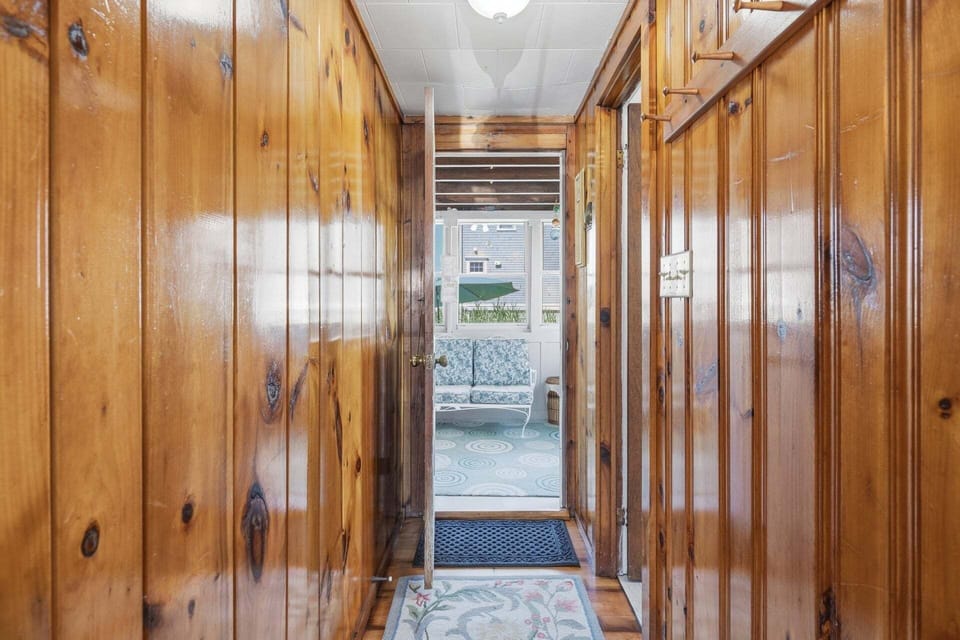 Hallway offering access to the bathroom and porch