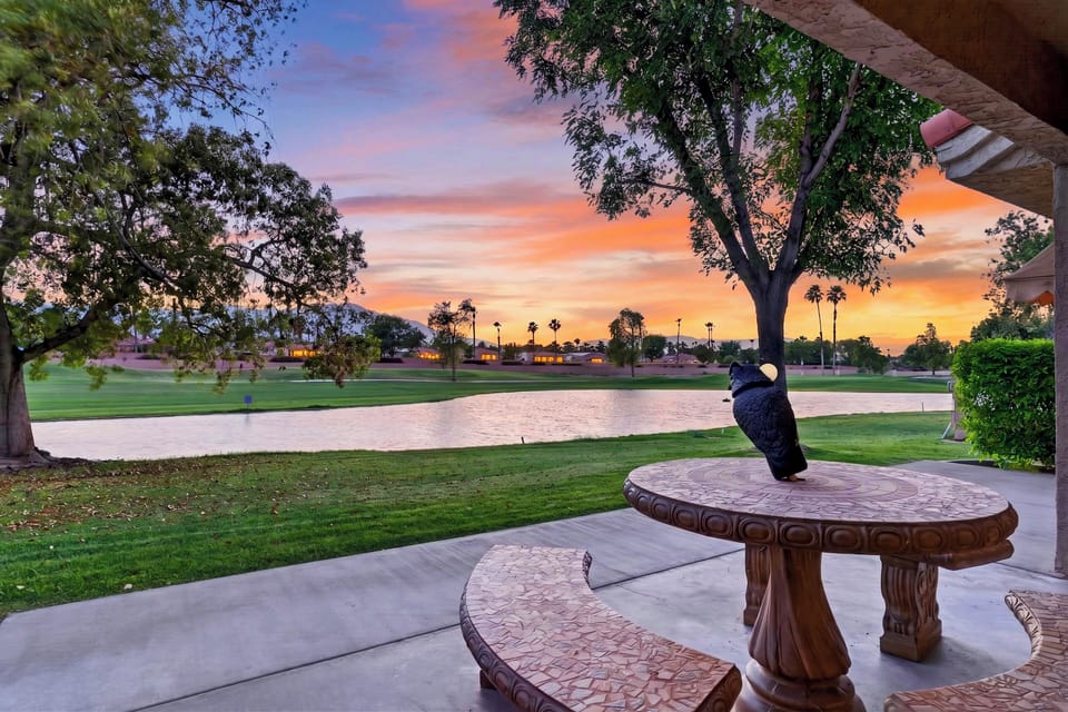 Vibrant desert sunset casting beautiful orange and pink hues across the tranquil golf course lake right from your backyard.