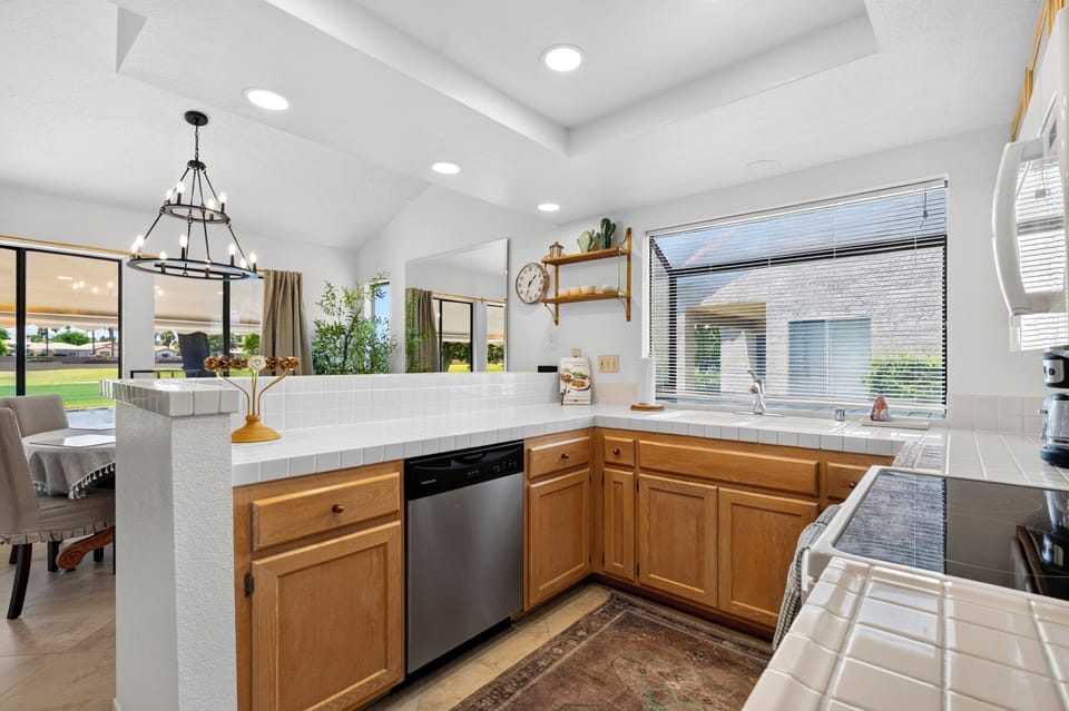 Wrap-around kitchen counters offering ample prep space, complete with open shelving accents and a view into the living areas.