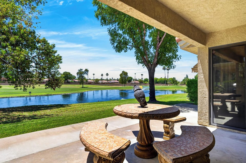 Perfect spot for morning coffee—a private covered patio featuring a classic stone seating arrangement overlooking the peaceful water.
