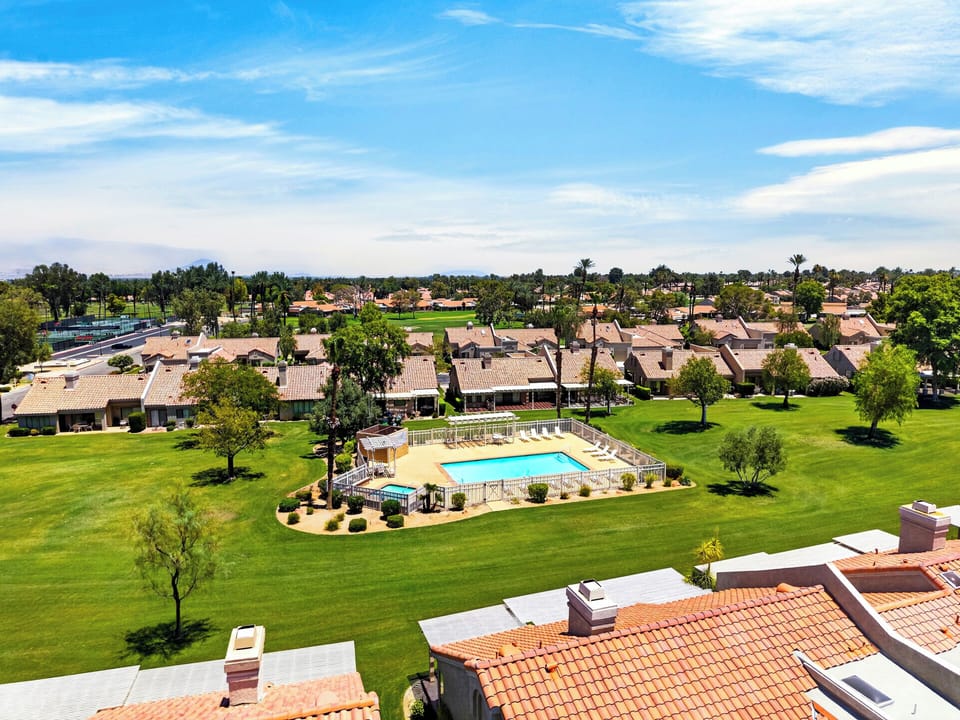 Aerial perspective highlighting the close proximity to the community swimming pool and beautifully manicured green spaces.