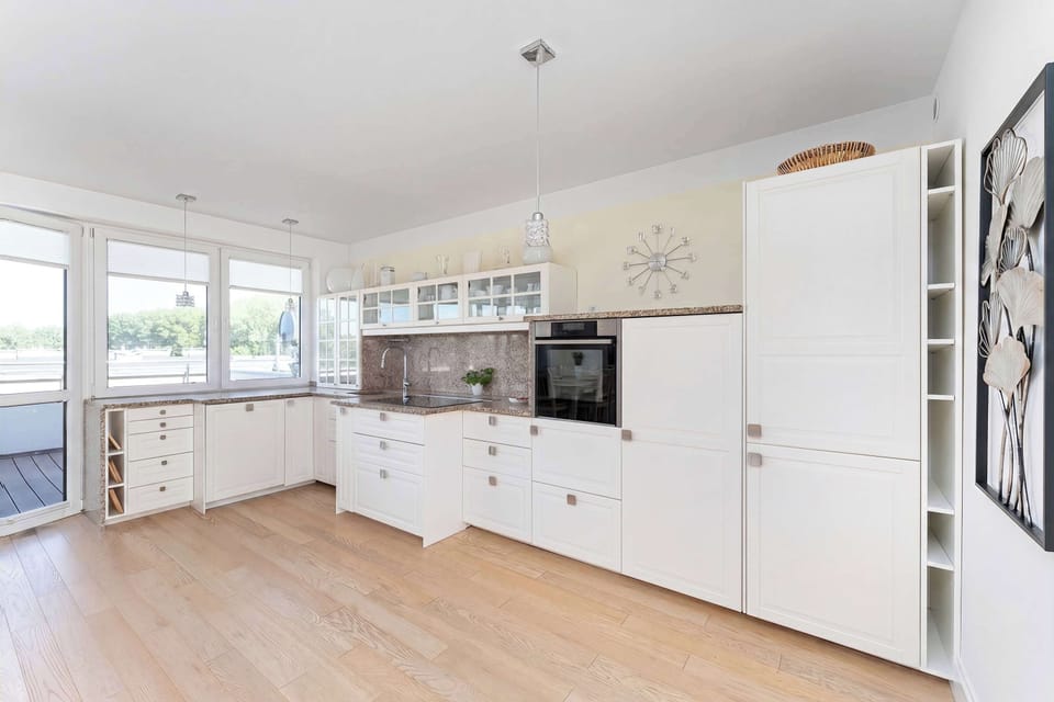 Contemporary kitchenette featuring extensive cabinetry, integrated appliances, and generous countertop space.
