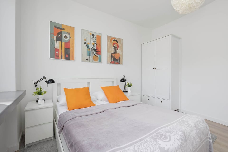 Bright master bedroom with a comfortable double bed and large windows.