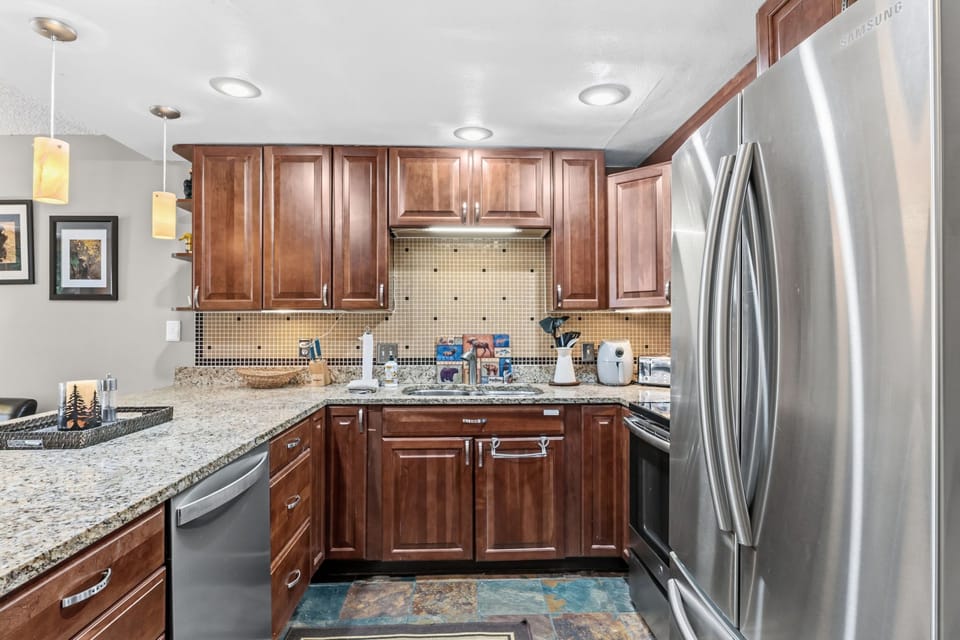 Your fully equipped kitchen features granite countertops, stainless steel appliances, and rich cherry cabinets—perfect for preparing meals during your stay.
