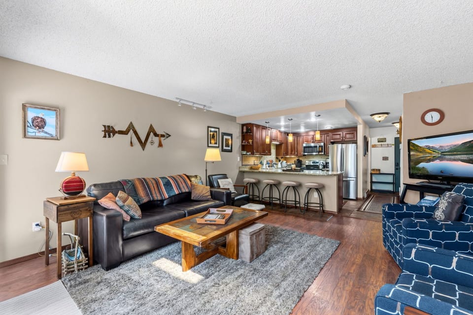 Unwind in this inviting open-concept space where your living room flows seamlessly into a fully equipped kitchen. Sink into comfortable seating, gather around the handcrafted coffee table, and make yourself at home.
