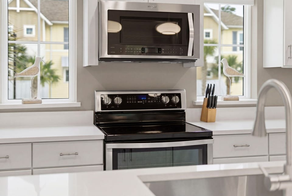 Turtles Nest- Cook your favorite meals in this bright, modern kitchen with stainless steel appliances, plenty of counter space, and natural light streaming through large windows overlooking palms.