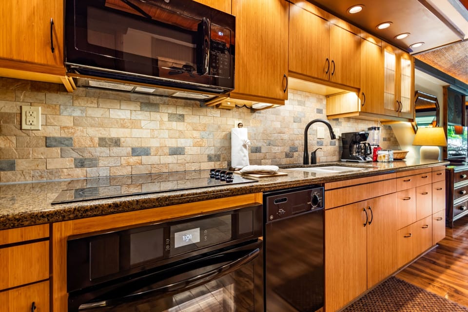 Step into your fully equipped kitchen with granite counters, warm wood cabinetry, and modern appliances—everything you need to cook up your favorite meals on the road.