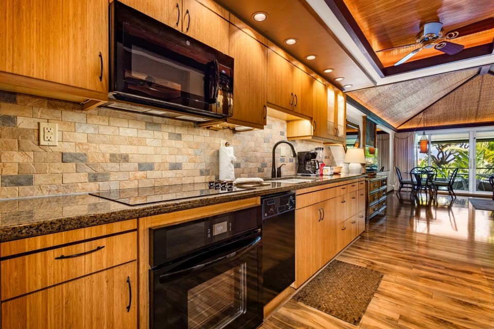 Step into your fully-equipped kitchen with granite counters, bamboo cabinetry, and natural light streaming in. Prepare island-inspired meals while enjoying tropical views through sliding doors.