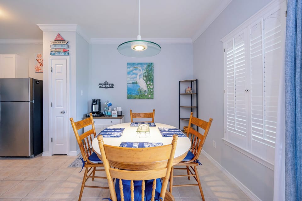 A bright dining area welcomes you to enjoy meals and coffee beside cheerful coastal decor and shutters