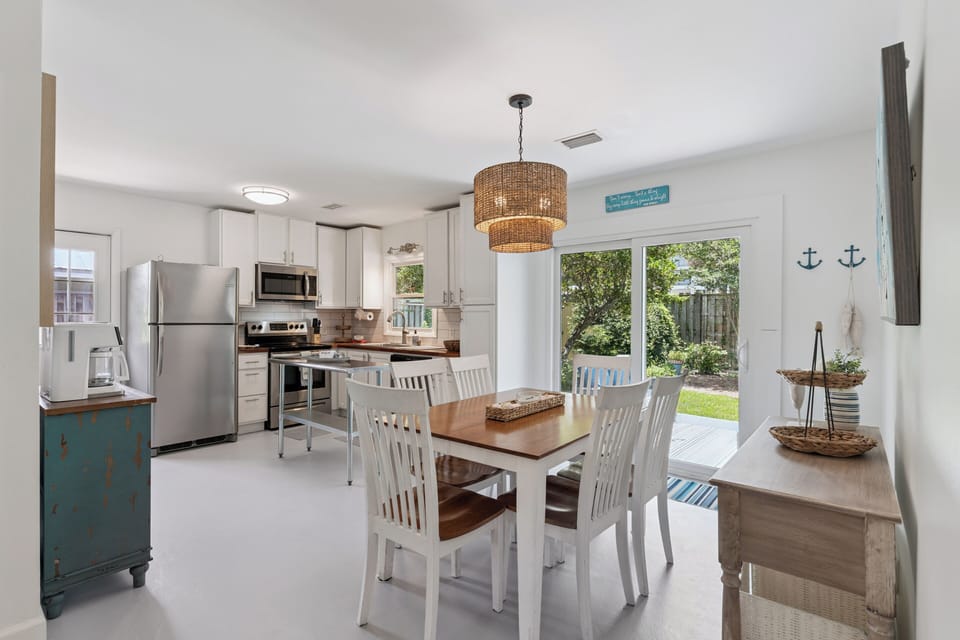 Gather around the dining table overlooking your private backyard, where meals feel like home with coastal charm, modern appliances, and natural light filling every corner.