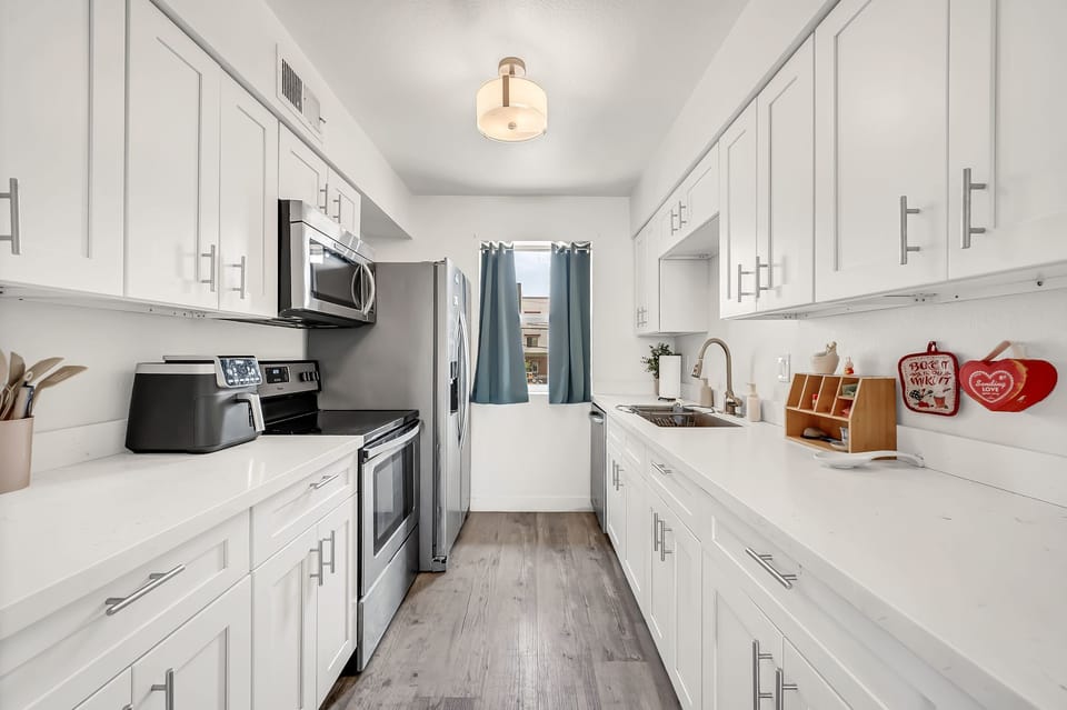 Bright modern kitchen with stainless steel appliances and ample counter space.