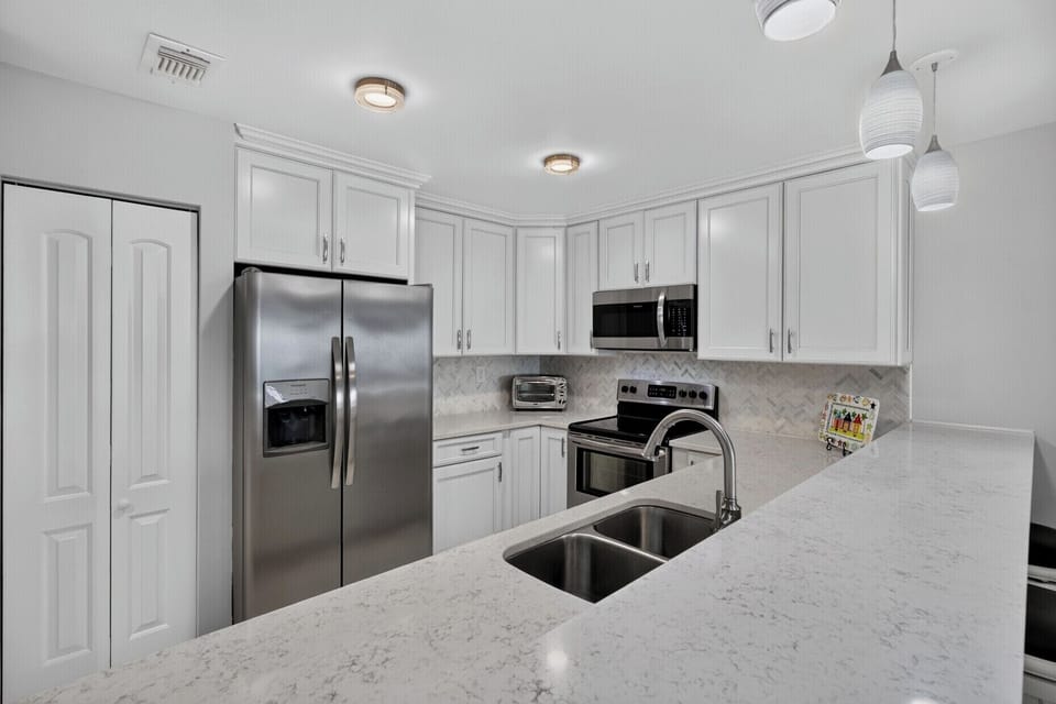 Your fully-equipped kitchen features sleek stainless appliances, bright countertops, and ample storage—perfect for preparing meals or enjoying your morning coffee in style.