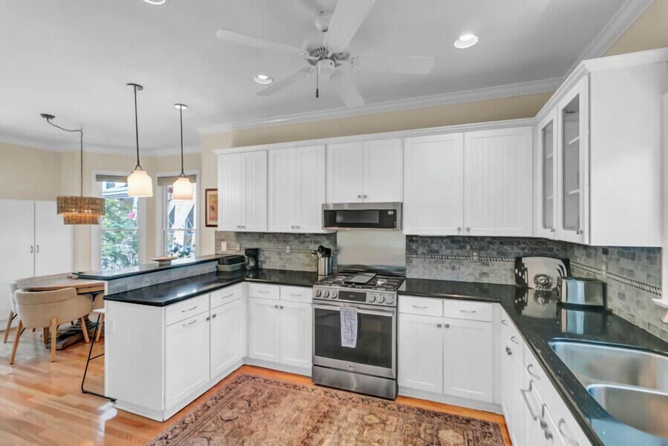 Step into your fully equipped kitchen, where white cabinetry, granite counters, and modern appliances invite you to prepare meals with ease and style.