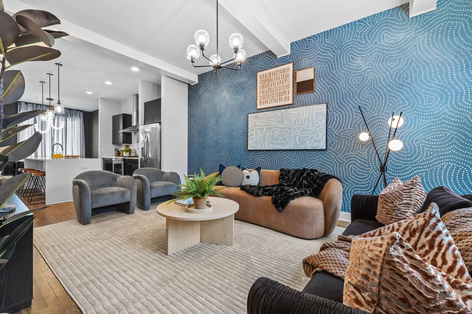Unwind in this stylish, designer-curated living room featuring plush seating, bold statement wallpaper, and an inviting space to relax, connect, and recharge after a day in Nashville.