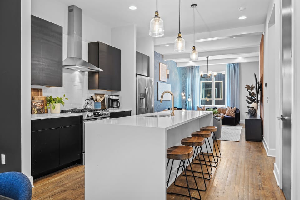 Bright, fully equipped kitchen with a spacious island, bar seating, and an open-concept layout perfect for gathering, dining, and entertaining.