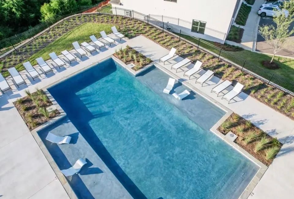 Resort-style pool with sun shelves, in-water loungers, and ample deck seating