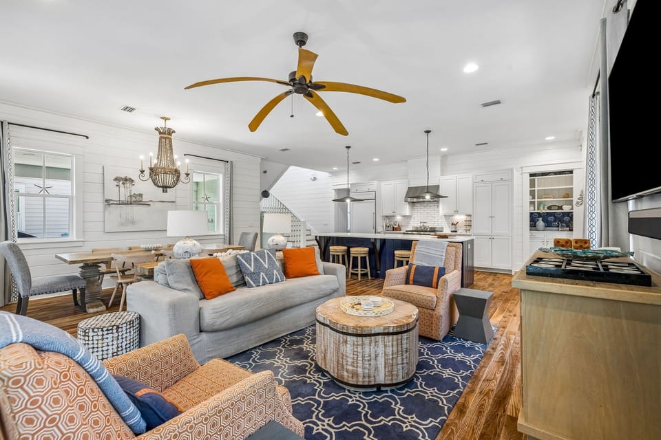 Settle into your open-concept living space where coastal style meets homey comfort—plush seating, warm wood tones, and natural light create the perfect gathering spot for your crew.