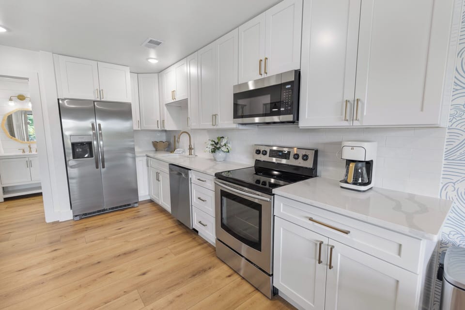 Step into your fully equipped kitchen with gleaming stainless-steel appliances, crisp white cabinetry, and plenty of counter space—perfect for preparing meals at your leisure.