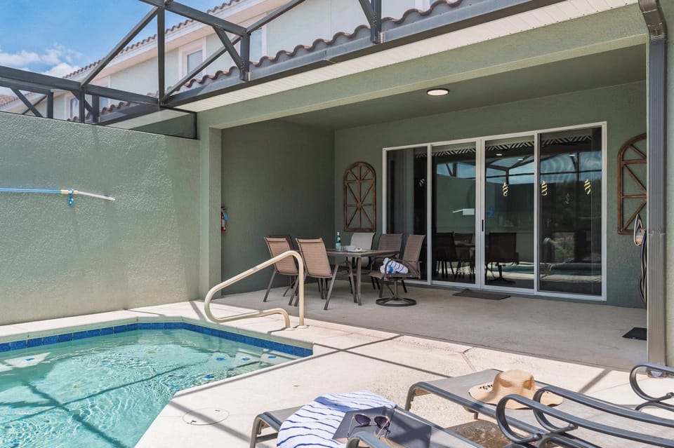 Covered patio with dining area overlooking a private pool
