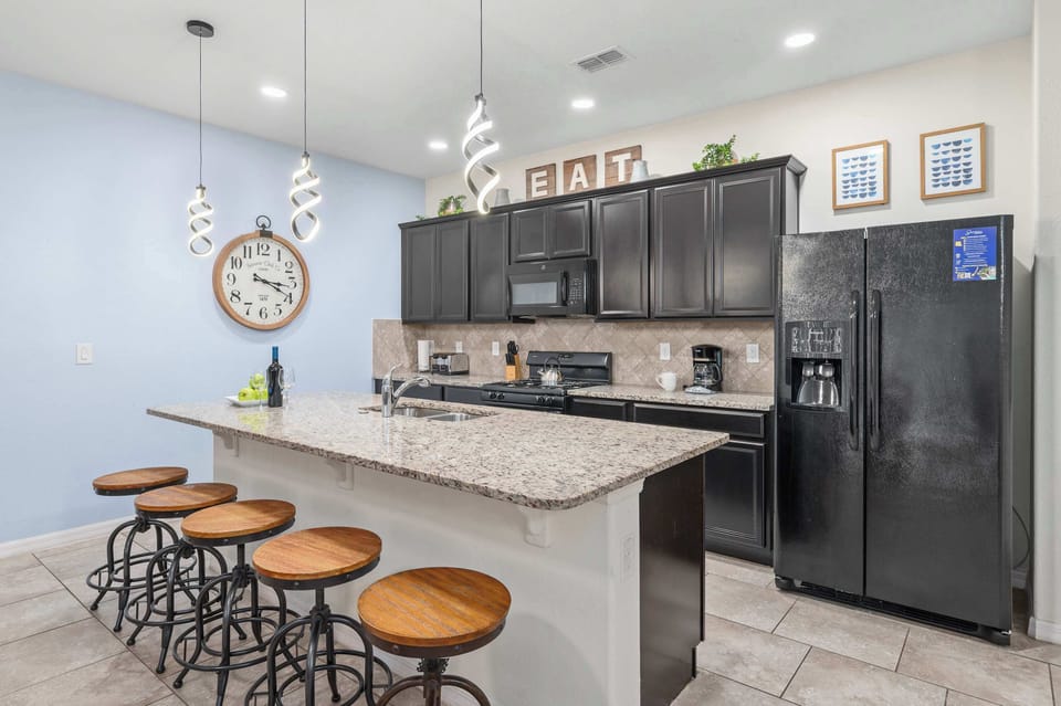 Modern kitchen with granite countertops and spiral pendant lighting over the breakfast bar