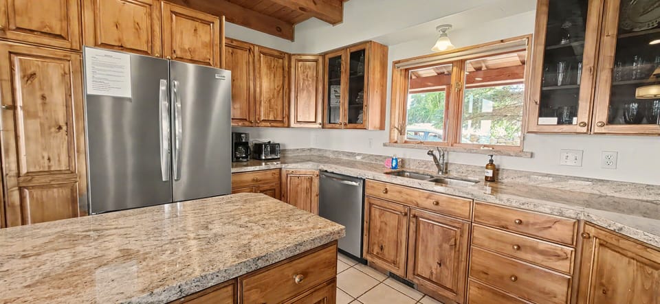 Rustic full kitchen with granite counters, island, and stainless appliances