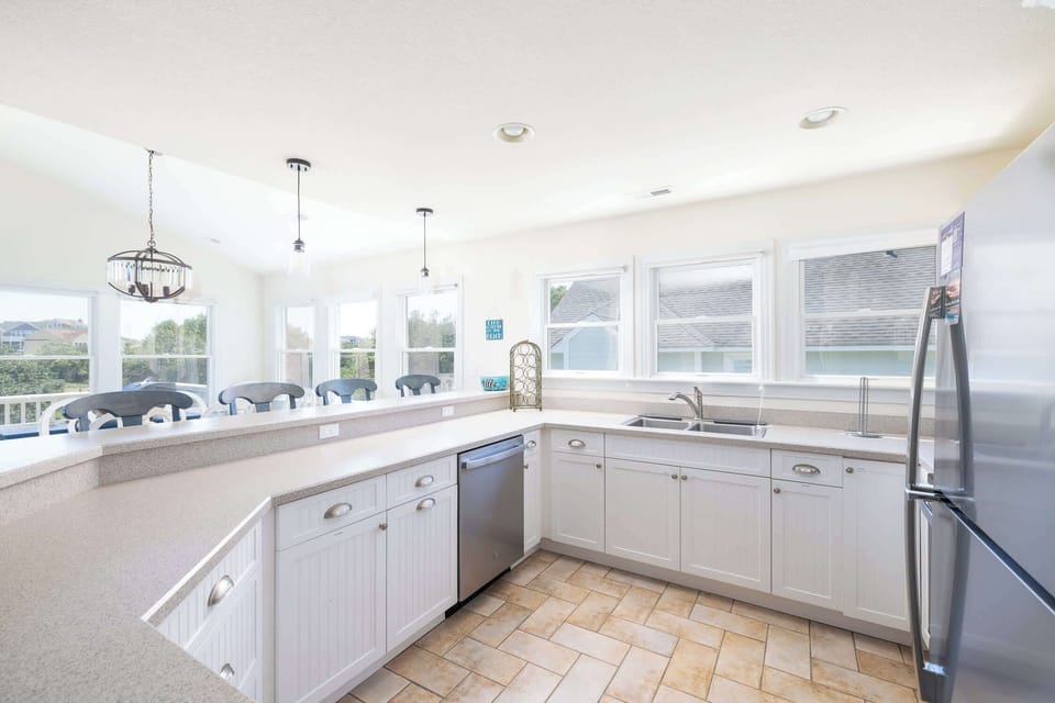 Fully Equipped Kitchen with Refrigerator, Range and Oven, Microwave, Dishwasher, Dual Coffee Makers, Ample Counter Space, and a Breakfast Bar with Seating, Perfect for Preparing Meals and Gathering with Family and Friends