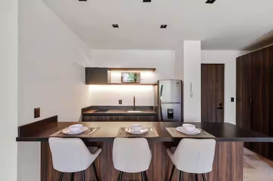 Open kitchen and dining bar with place settings, ideal for meals or remote work.