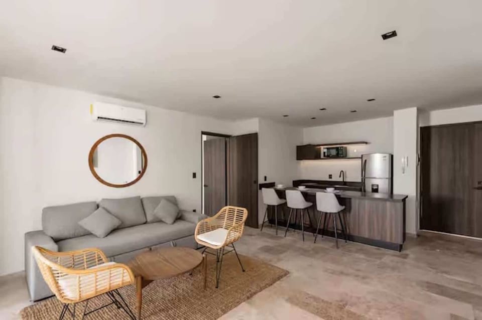 Open living area with sofa seating, dining bar, and warm natural finishes.