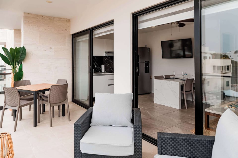 Private balcony with outdoor seating and direct access to the apartment, perfect for morning coffee or relaxing after a day in Playa del Carmen.
