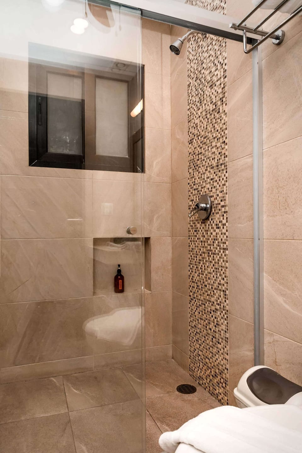 Walk-in shower with a sleek tile design, perfect for refreshing after the beach or rooftop pool.