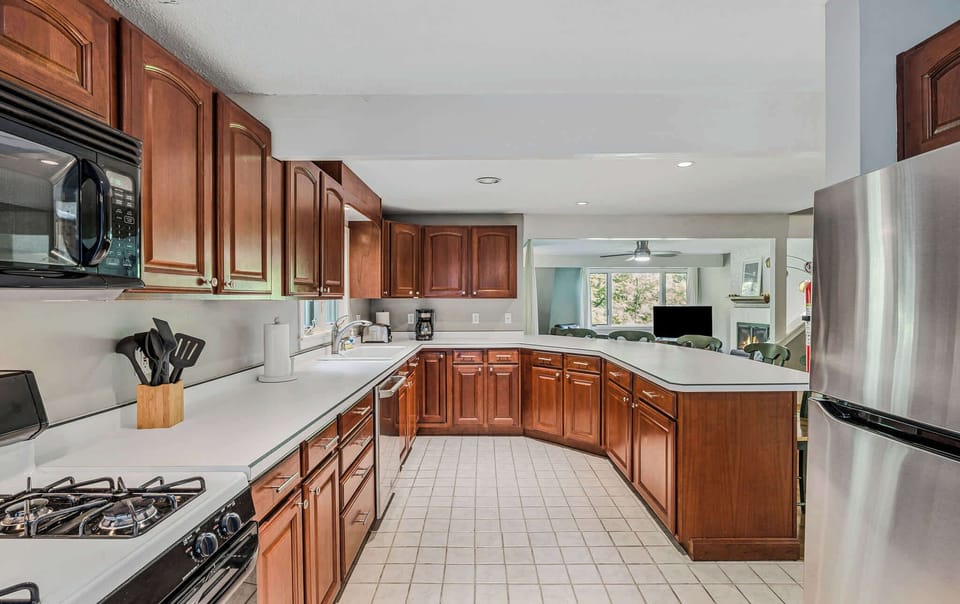 Full kitchen with cherry cabinets and stainless steel appliances