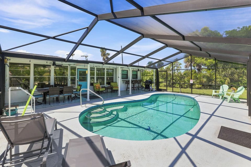 Private screened pool lanai with tropical views and outdoor dining