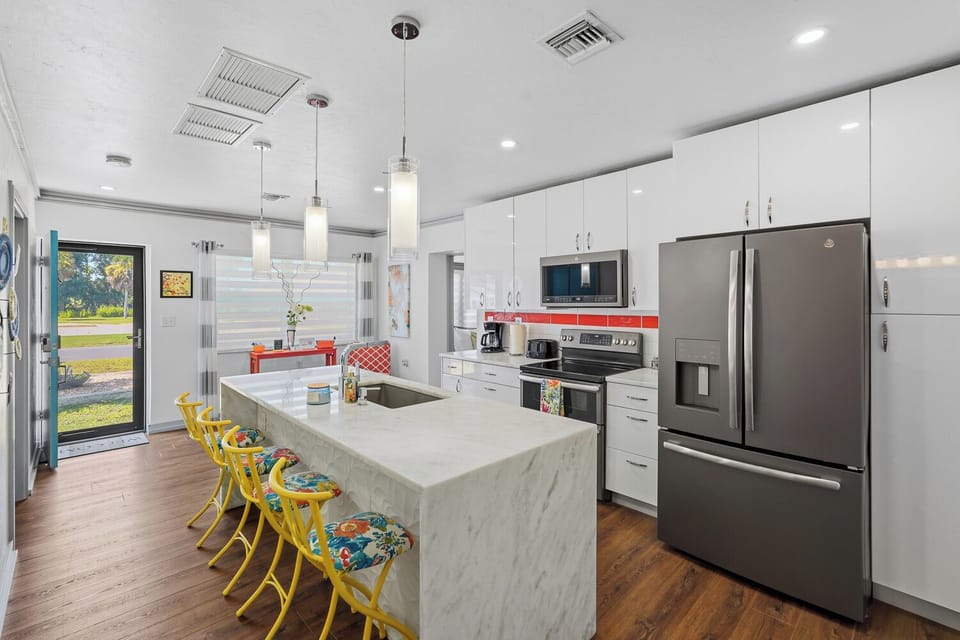 Bright modern kitchen with waterfall island and colorful seating