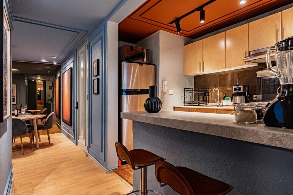 Kitchen with a breakfast bar, full-size fridge, and essential appliances.