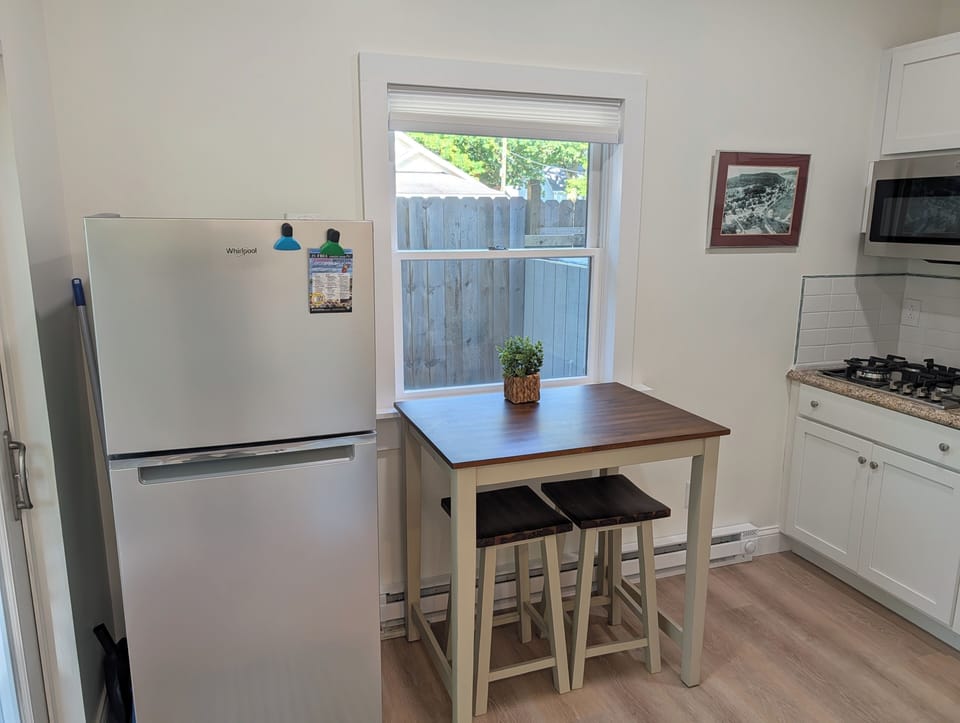 KITCHEN: The apartment's cute kitchen with a stove, microwave, coffeemaker, refridgerator, and other kitchen essentials. Perfect for cooking! The cute dining table offers a place to eat