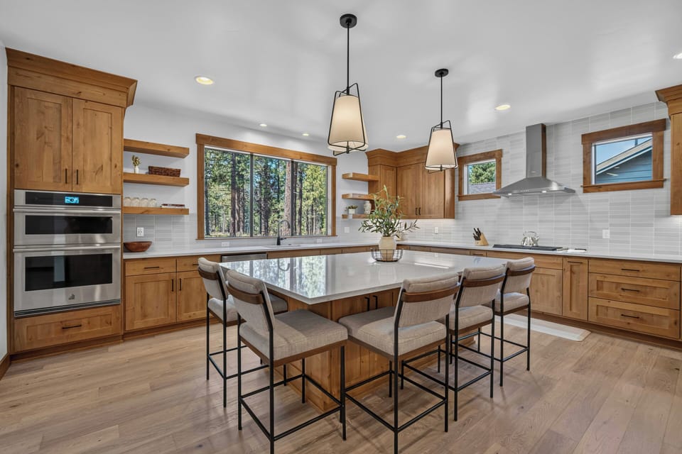 Gather around this spacious kitchen island, bathed in natural light from forest views, where meal prep becomes a relaxing part of your mountain retreat.
