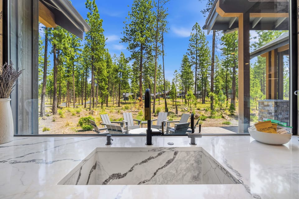 Soak in this stunning marble soaking tub while gazing at towering pines and the tranquil forest beyond your private windows—a perfect sanctuary for relaxation.