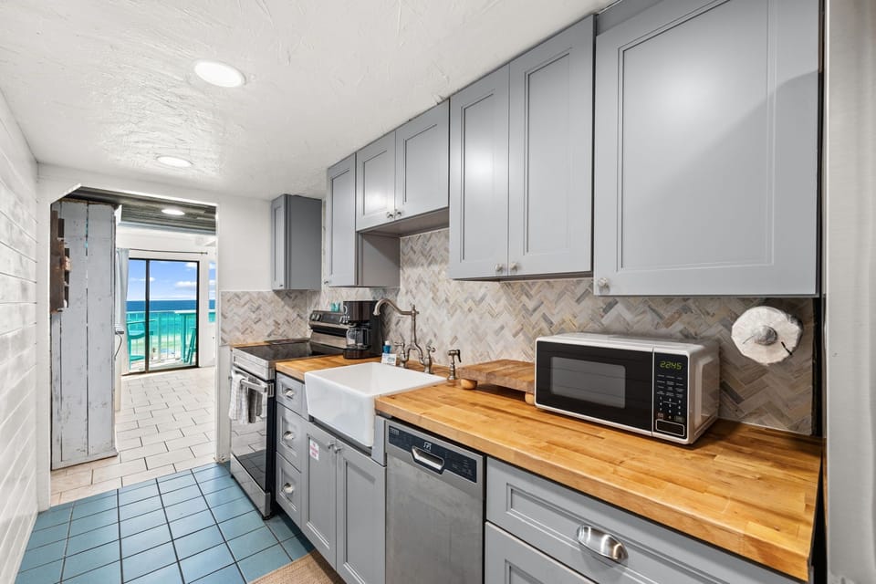 Your fully equipped kitchen opens directly to a stunning ocean view balcony—imagine sipping morning coffee while watching waves roll in just steps from where you prep meals.