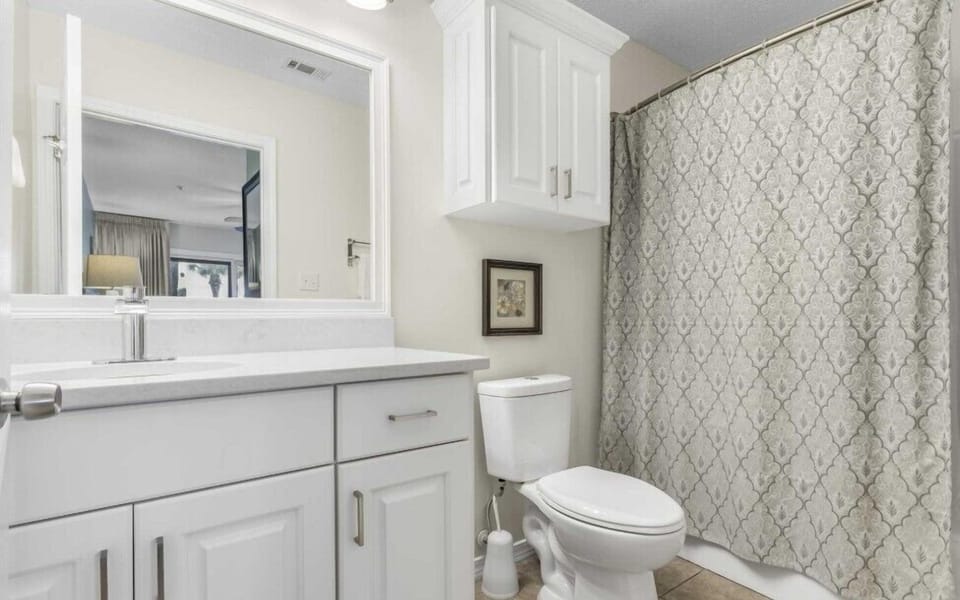 Updated primary bathroom with quartz vanity and shower/tub combination.