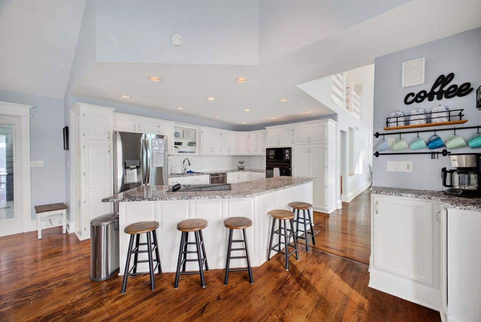 Gather around the spacious kitchen island, where gleaming granite countertops and plenty of seating invite you to share meals and make memories together in this bright, beautifully designed space.