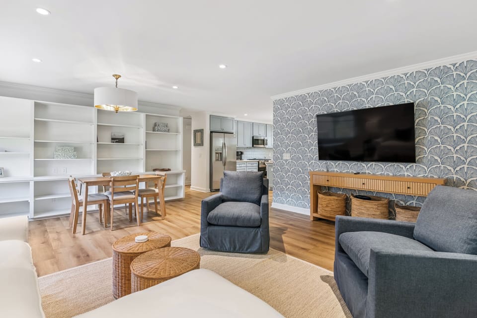 You'll love unwinding in this open-concept living area, where stylish coastal design meets comfort—catch your favorite show, gather for meals at the dining table, or prepare snacks in the modern kitchen.