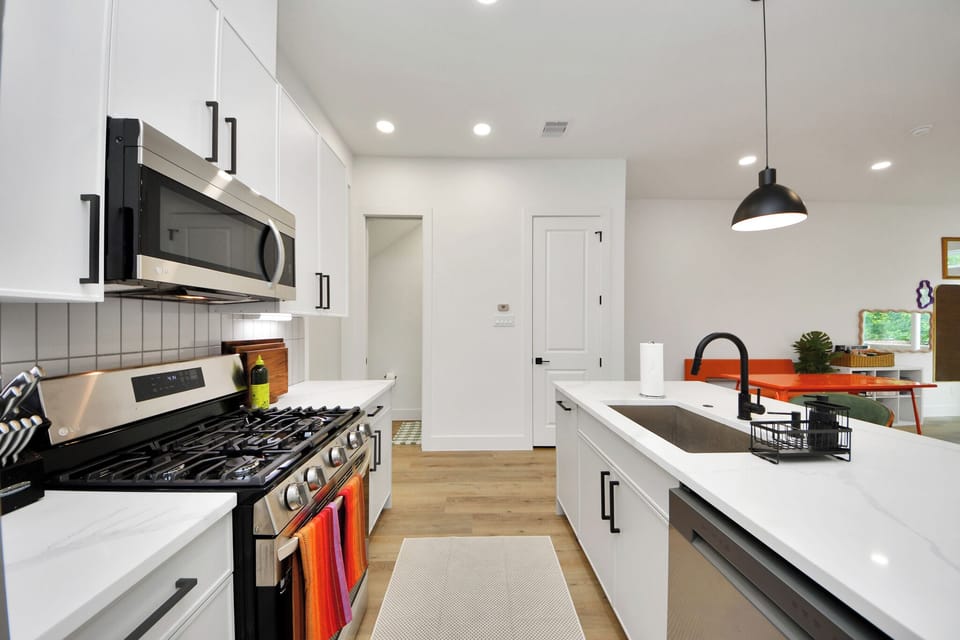 Bright modern kitchen with gas range, large island, and open dining area