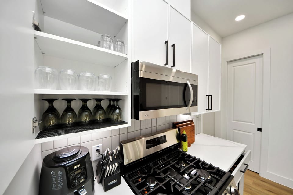 Bright modern kitchen with gas range, stainless appliances, and stylish storage