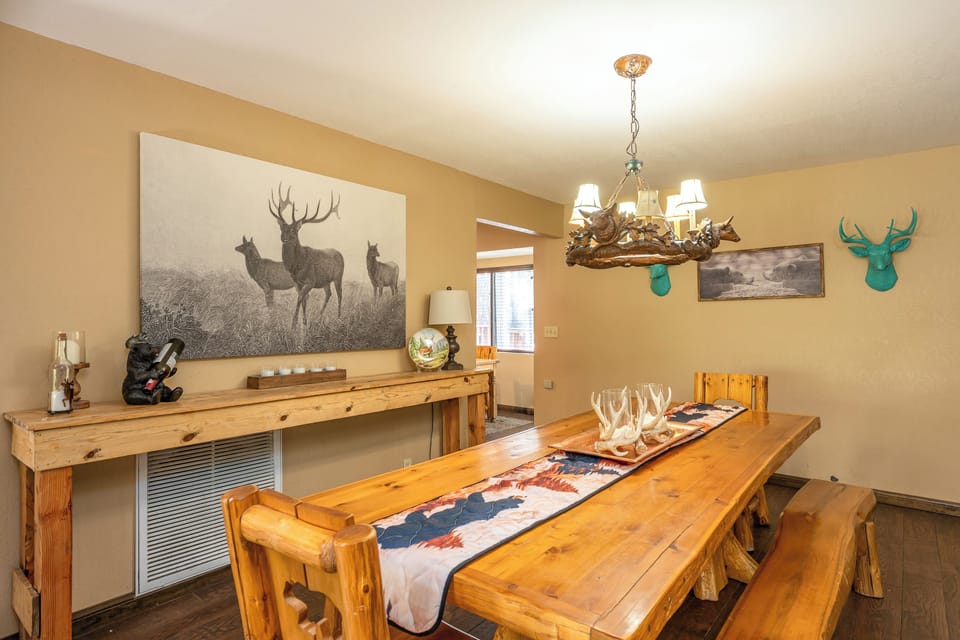 Your meals become memorable moments around this handcrafted pine table beneath a stunning antler chandelier—rustic charm meets modern comfort in your home away from home.