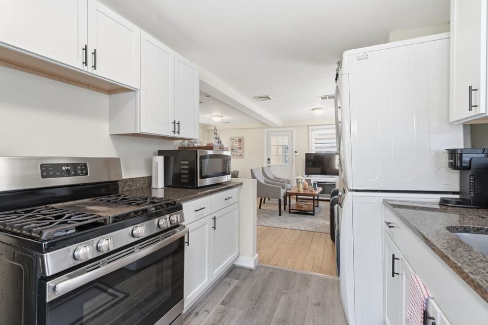Enjoy a seamless experience in this bright, open-concept kitchen that flows perfectly into the living area, complete with a gas range, dishwasher, and convenient laundry tower.