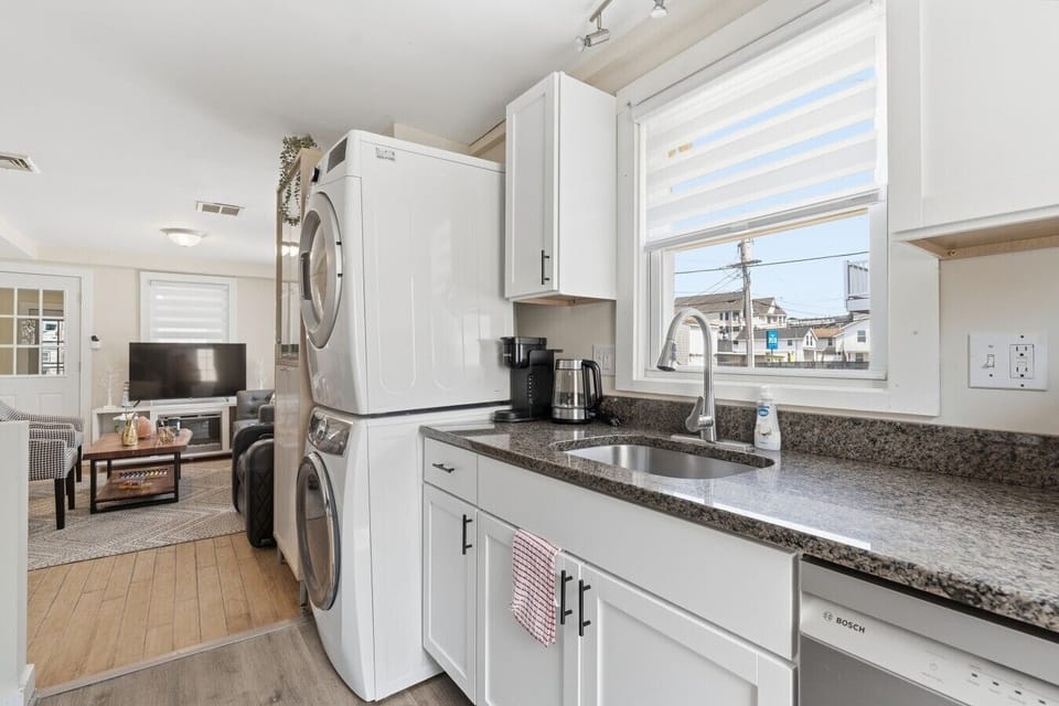 Enjoy a seamless experience in this bright, open-concept kitchen that flows perfectly into the living area, complete with a gas range, dishwasher, and convenient laundry tower.