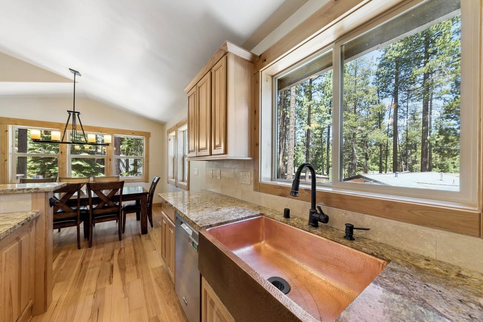 Sunlight pours into your kitchen, highlighting the copper sink and granite counters. Just beyond, towering pines frame your mountain retreat—every meal prep offers a serene forest backdrop.
