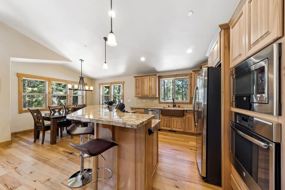 Your spacious, light-filled kitchen invites you to gather with family. Warm wood cabinets, granite countertops, and modern appliances await your culinary adventures. Enjoy tree-lined views through every window.