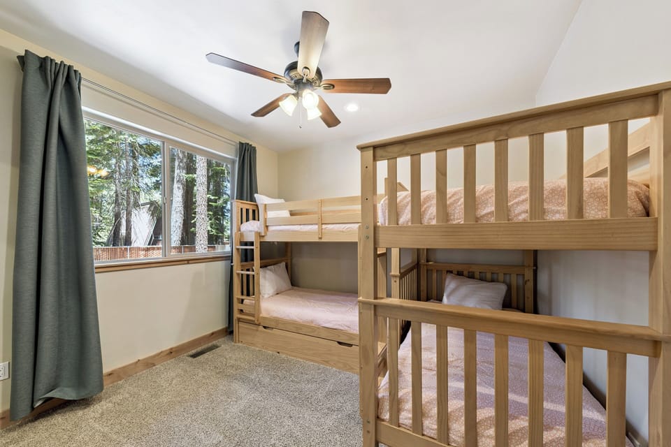 Cozy bunk room with forest views where kids can drift off to sleep after a day of adventure. Ceiling fan keeps the room comfortable year-round.