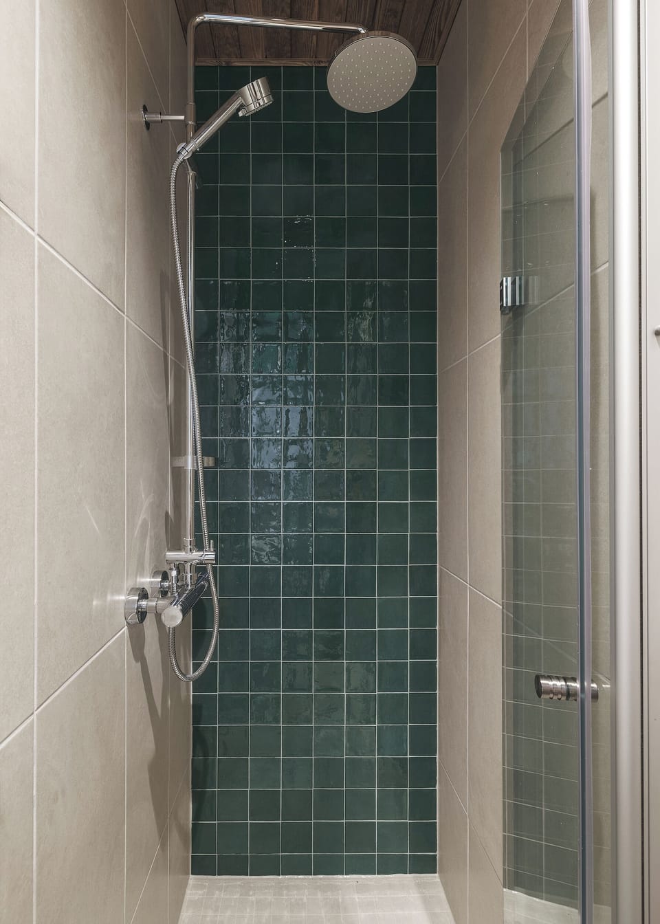 Modern walk-in shower with rainfall head and stylish green tile